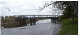 A bridge over water with trees in the background