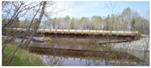 A bridge over water with trees in the background